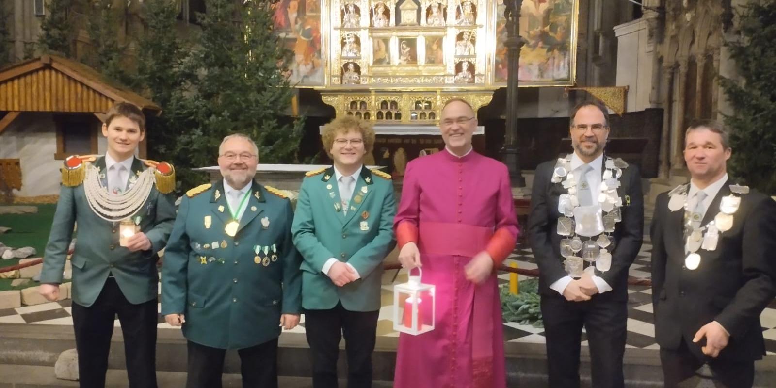 v.l.n.r. Bezirksjungschützenmeister Moers Sebastian Janßen, Diözesanjungschützenpräses Theo van Doornick,  Bezirksjungschützengeschäftsführer Moers Linus Wolny, Weihbischof Rolf Lohmann,  Schützenbrüder der St. Kosmas & Damian Schützenbruderschaft Hülm-Helsum